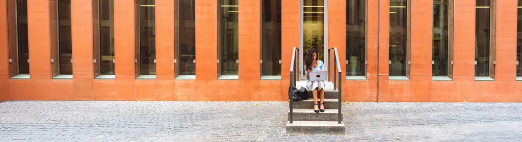 Mujer sentada en escaleras mirando el móvil