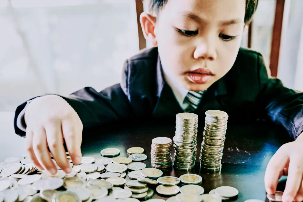 Un niño haciendo torres de monedas
