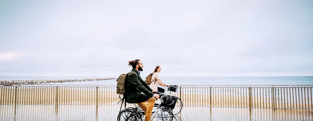 Un hombre y una mujer en bicicleta mirando el mar