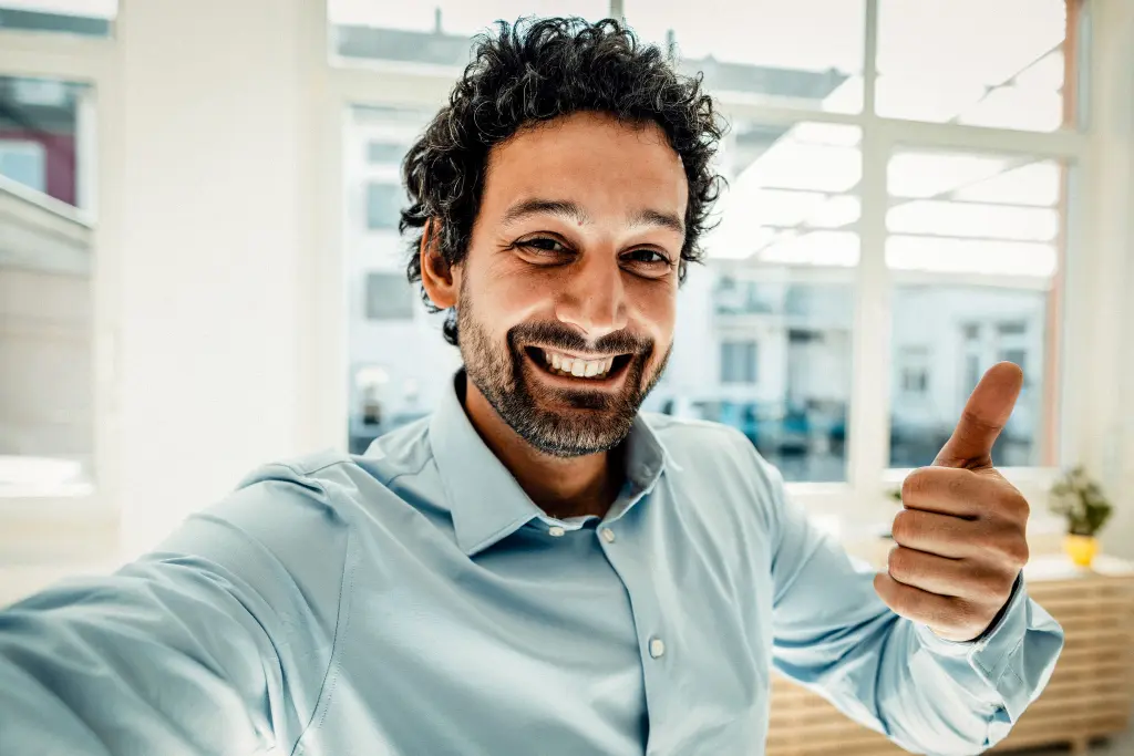 Hombre sonriente con camisa celeste en oficina