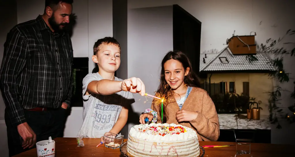 Dos niños encendiendo una tarta de cumpleañoso