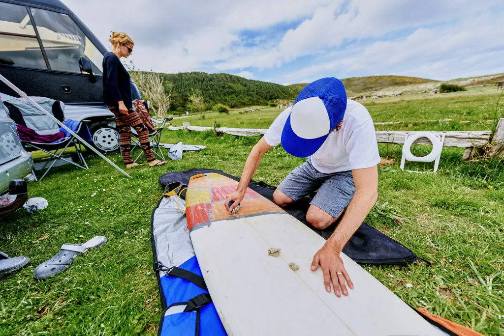 Chico limpiando su tabla de surf