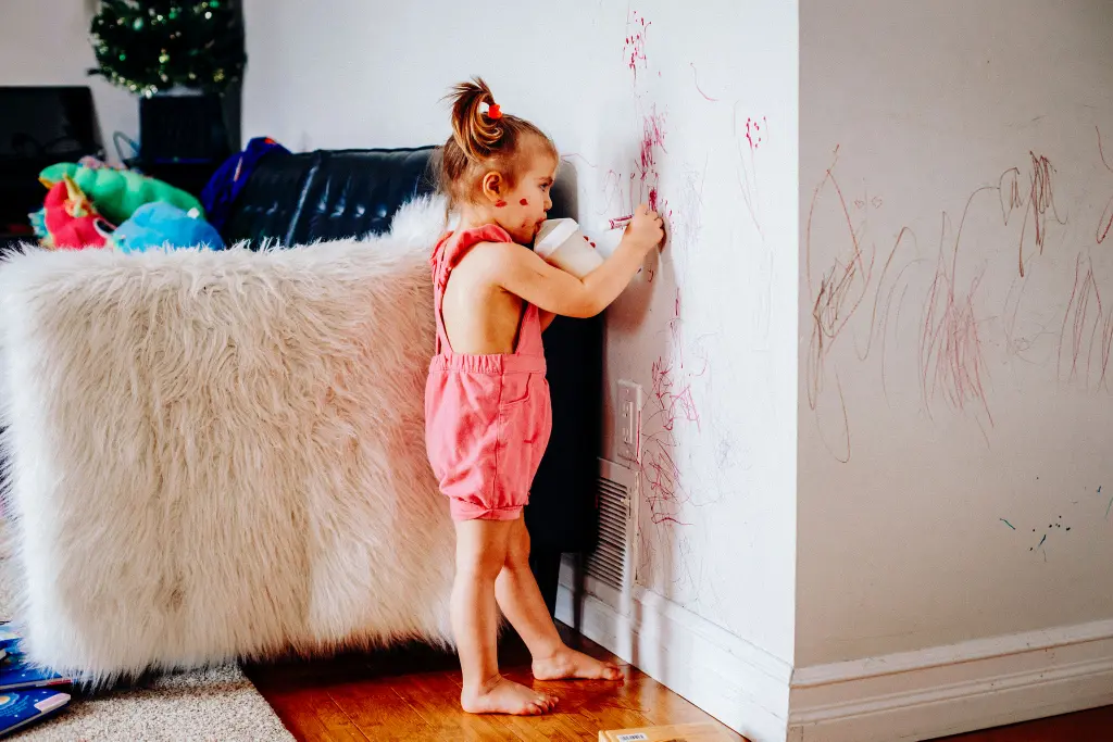 Niña pintando en una pared